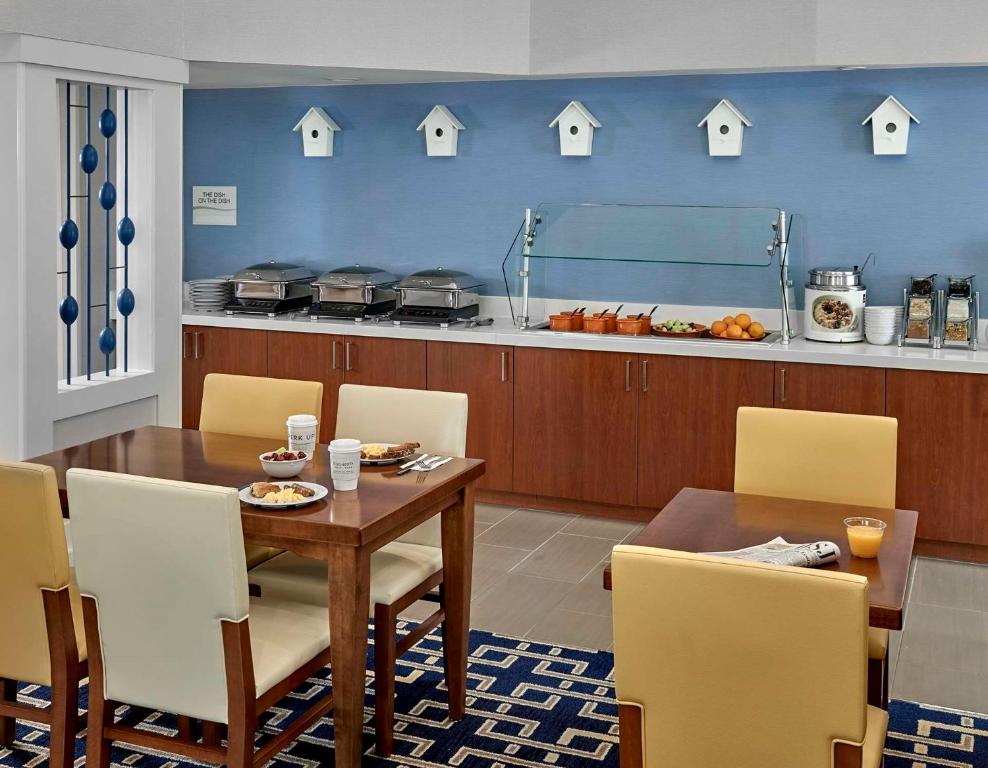 a dining room with a table and chairs and a kitchen at Sonesta ES Suites Tucson in Tucson