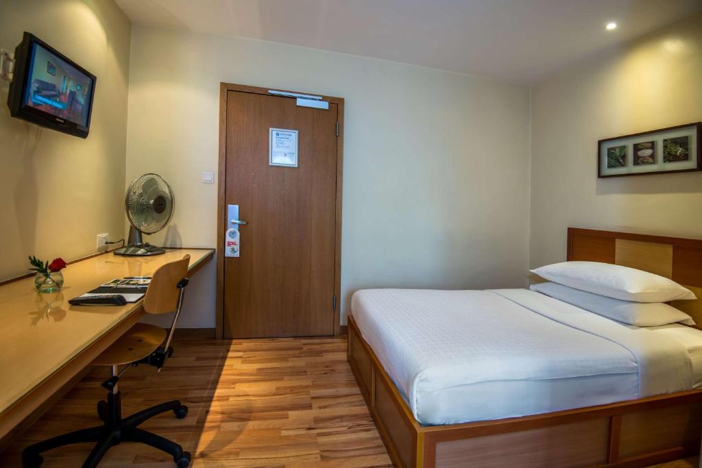 a hotel room with a bed and a desk and a door at Best Western Nairobi Upper Hill in Nairobi