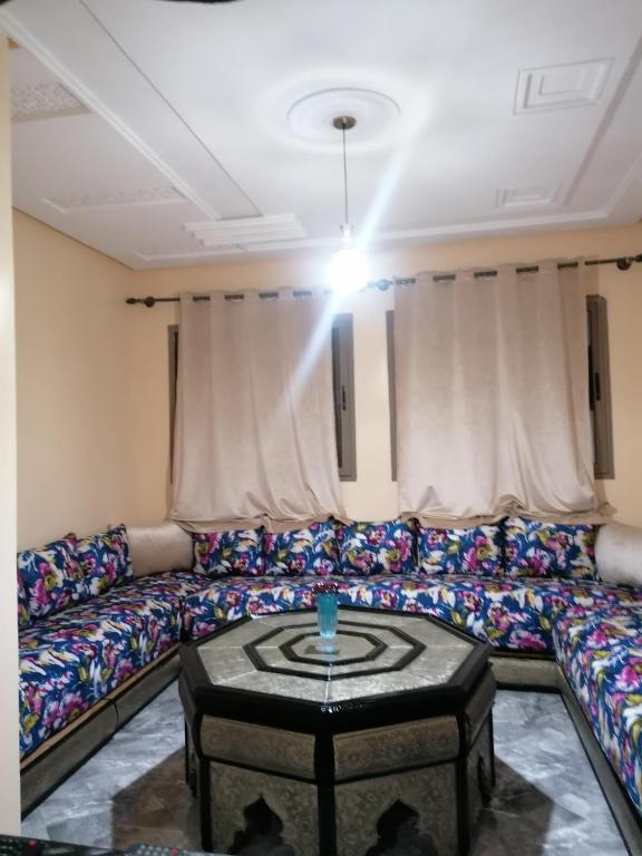een woonkamer met een bank en een tafel bij Le bel abri in Meknès