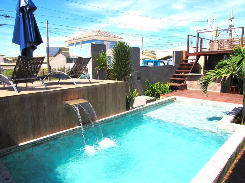a swimming pool with a water fountain at POUSADA ONDA CARIOCA in Cabo Frio