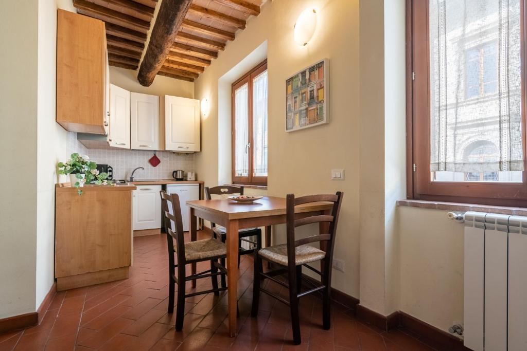 een keuken en eetkamer met een tafel en stoelen bij Appartamento La Torre Pendente in Pisa