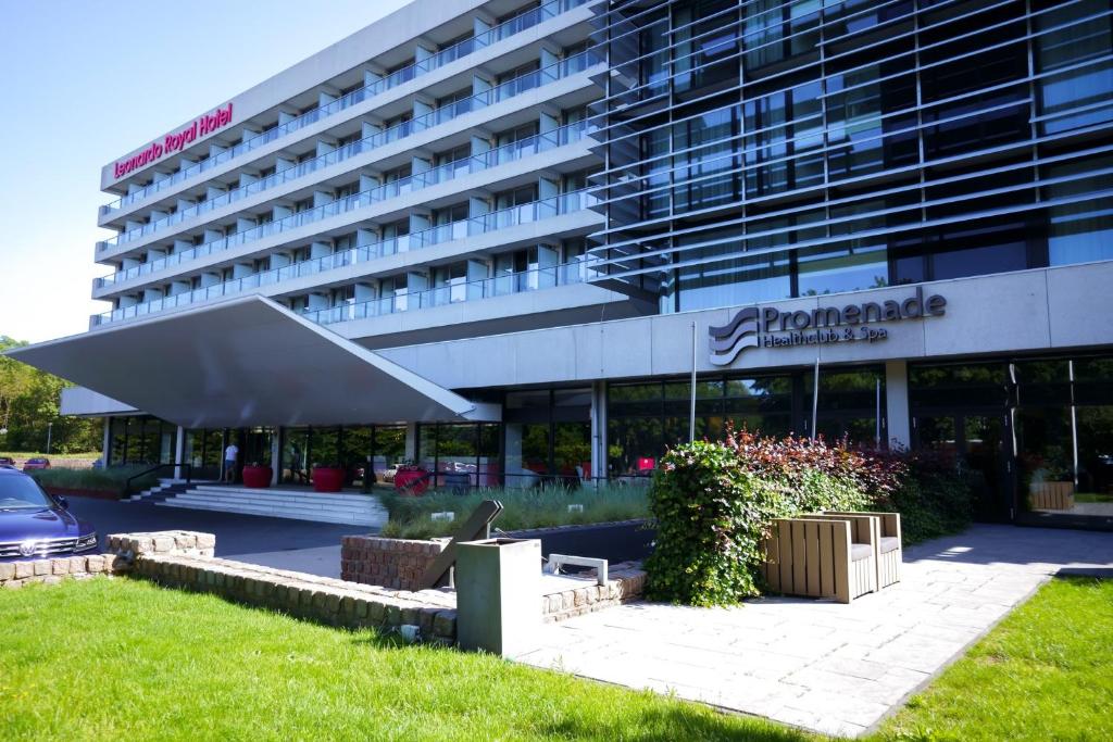 デン・ハーグにあるLeonardo Royal Hotel Den Haag Promenadeの正面に駐車場がある建物