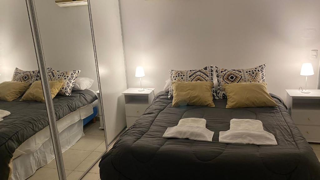 1 dormitorio con espejo y 1 cama grande en Departamento TIERRA V en Salta