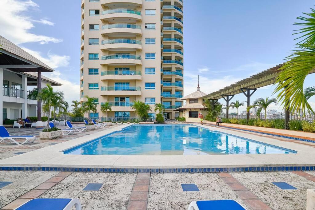 a swimming pool in front of a tall building at Luxurious Ocean View Suite in Santo Domingo