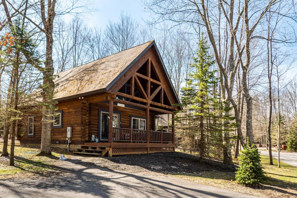 a log cabin in the woods with a porch at Evergreen in Oakland