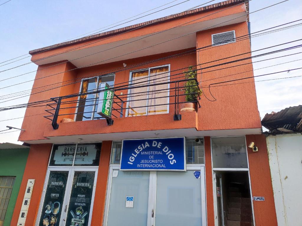 un edificio con un cartello blu davanti di Hotel La Vega real a La Vega