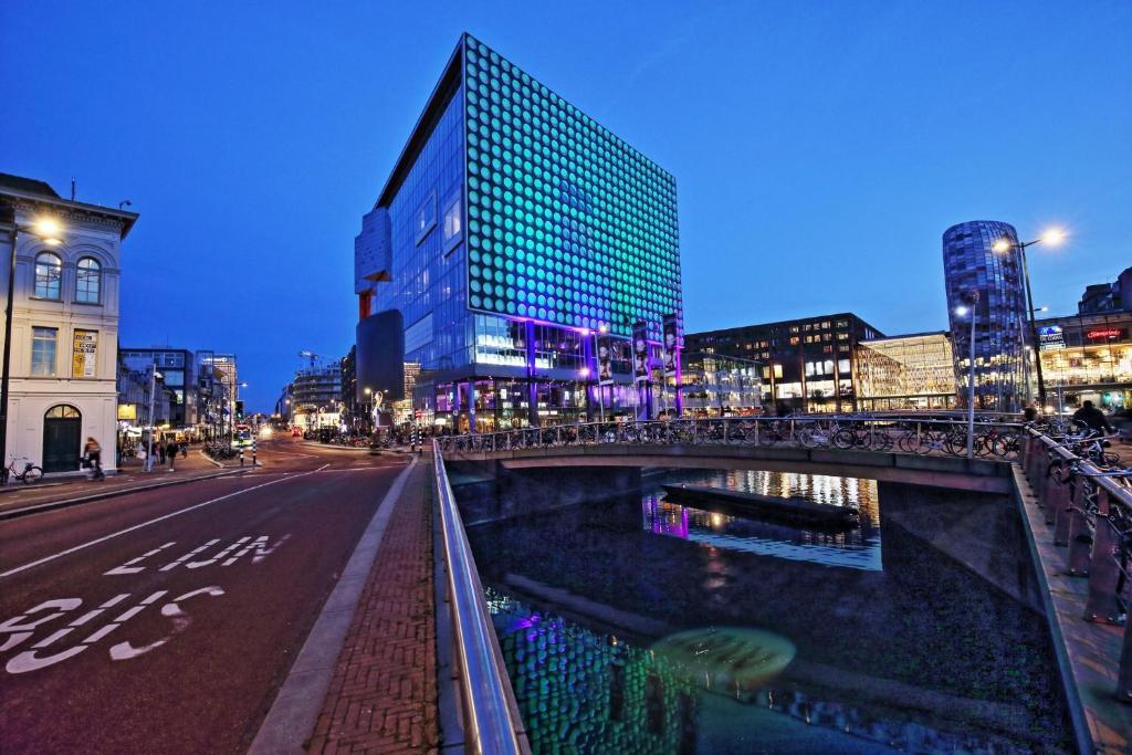 un puente sobre una calle en una ciudad por la noche en Leonardo Hotel Utrecht City Center, en Utrecht