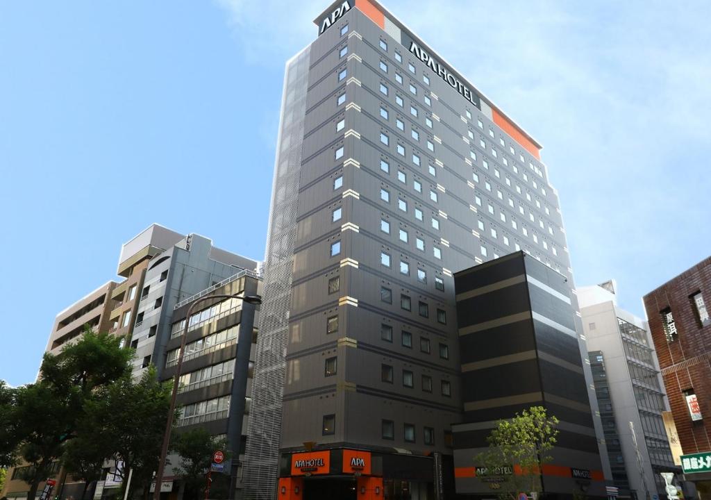 Un grand bâtiment avec un panneau en haut dans l'établissement APA Hotel Omori Ekimae, à Tokyo