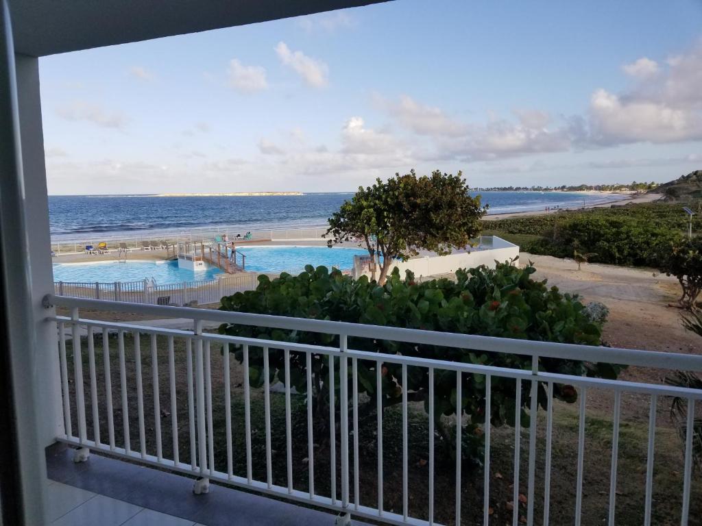 Blick auf den Strand vom Balkon eines Resorts in der Unterkunft Orient Bay Beach Studio in Orient Bay