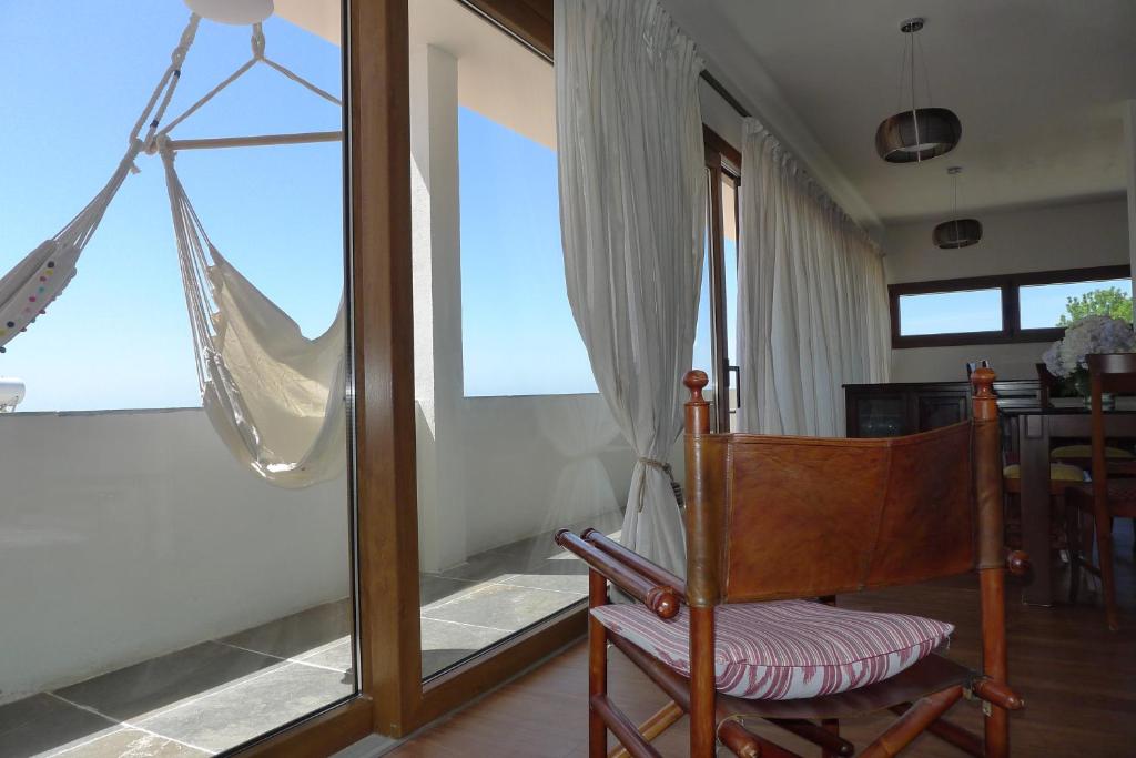ベヘール・デ・ラ・フロンテーラにあるFinca Higueronの椅子とハンモック付きの窓が備わる客室です。