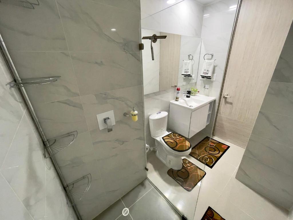 e bagno con servizi igienici e doccia in vetro. di Moderno y cómodo apartamento en Puerta del Sol a Bucaramanga