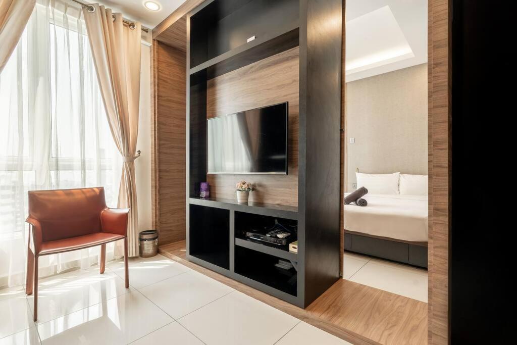 Un dormitorio con una cama y un televisor en una habitación. en Mansion One Executive Studio 2pax, en George Town