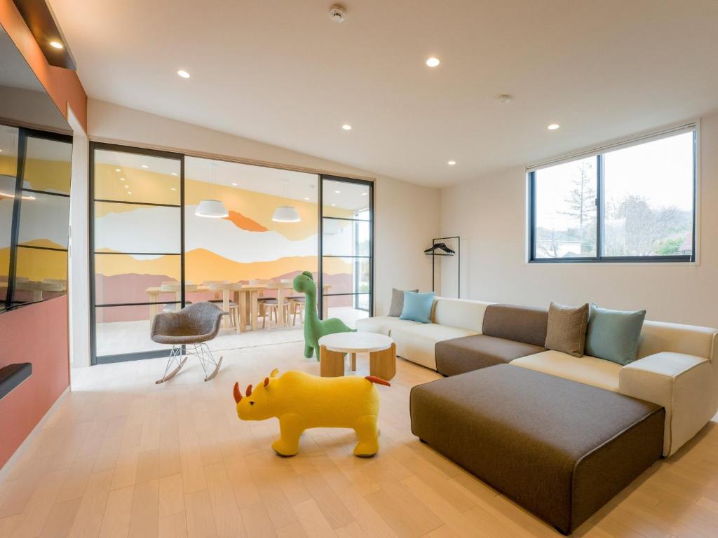 sala de estar con sofá y juguete para perros en Rakuten STAY VILLA Yatsugatake - 103 Family Room Pets Friendly -, en Hokuto