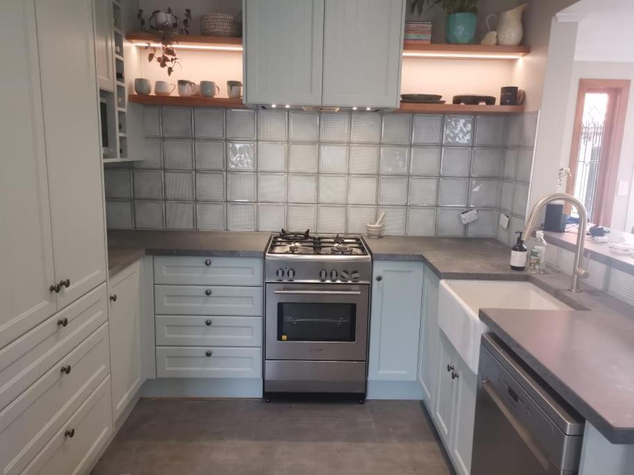 a kitchen with a stove and a sink at Redwoods Character Cottage & Studio in Rotorua