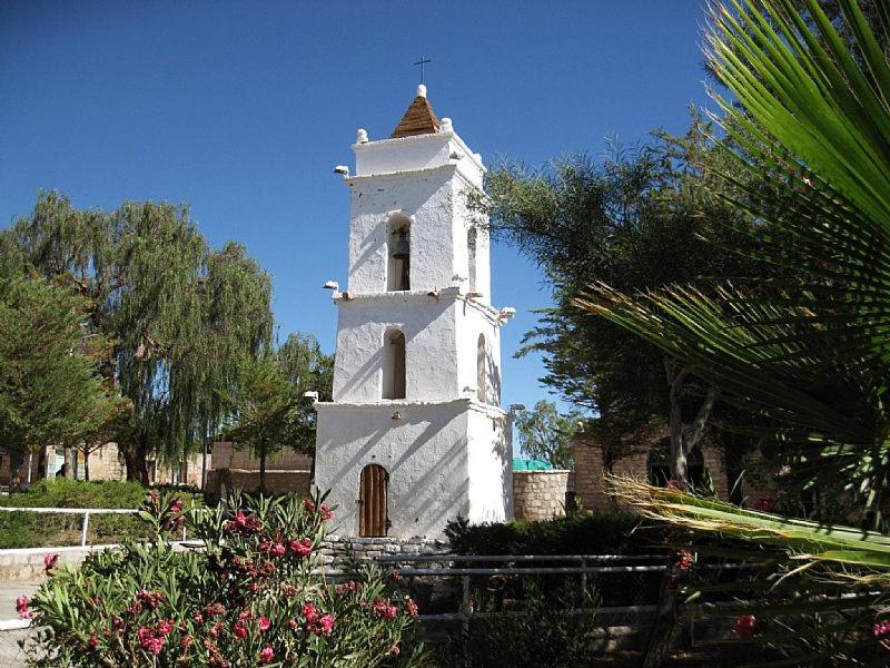 Una torre blanca con una cruz encima. en Alojamiento en Toconao paraíso Terrenal, en Toconao
