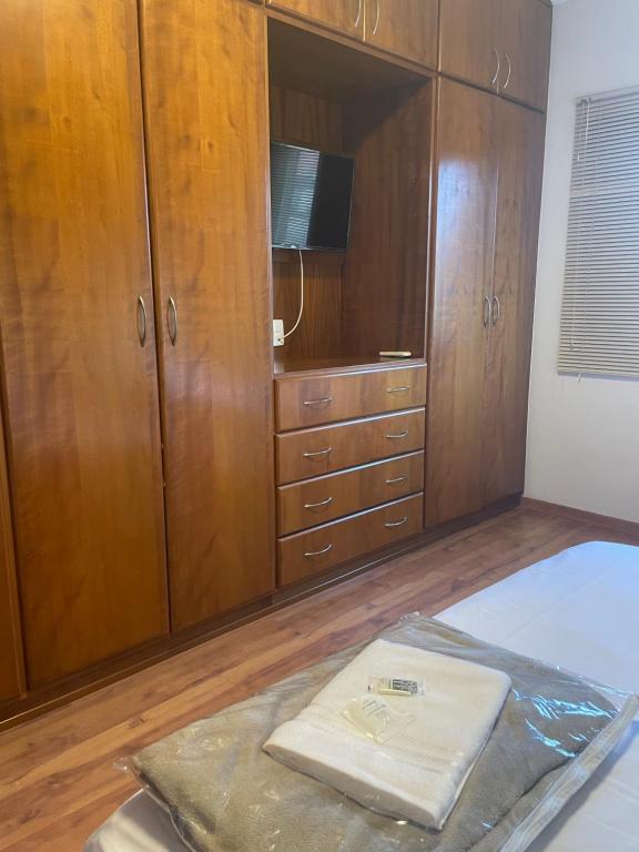 a bedroom with wooden cabinets and a bed and a tv at Pousada & Hostel São Carlos in São Carlos