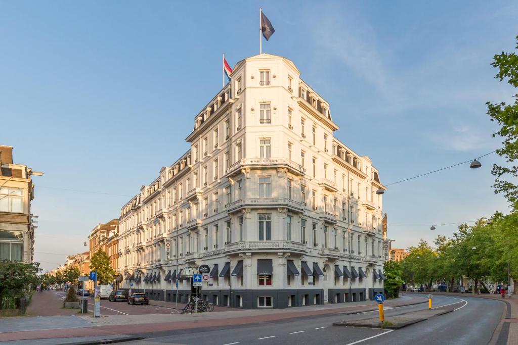 a white building with a flag on top of it at Leonardo Boutique Museumhotel in Amsterdam