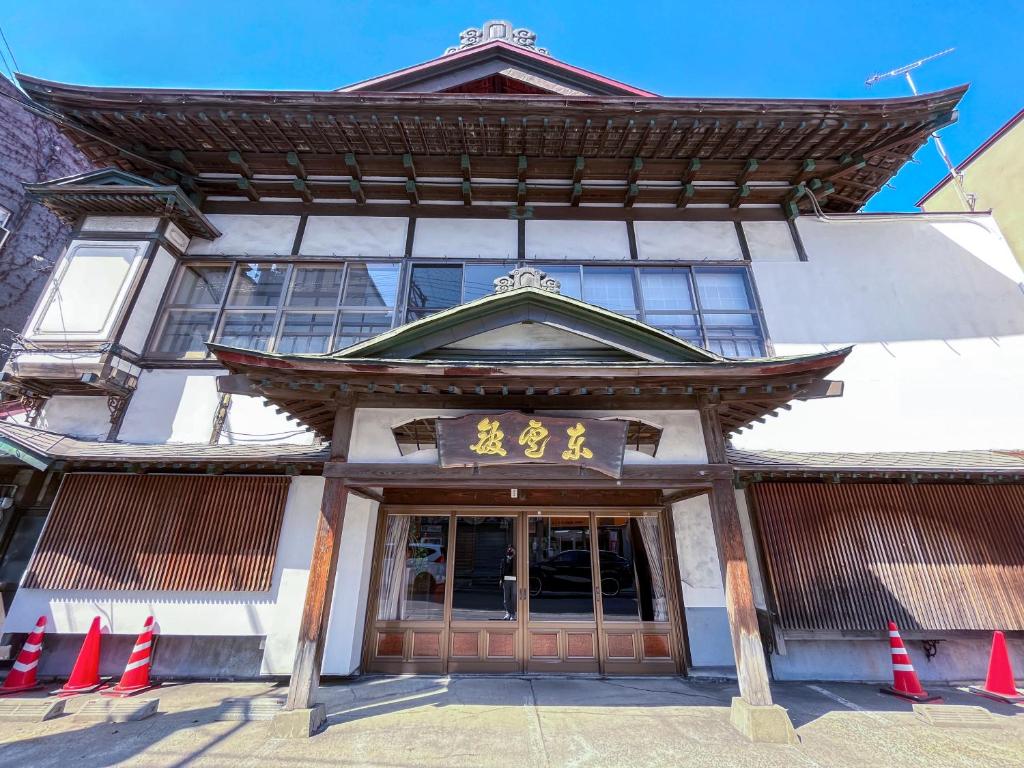 an asian building with orange cones in front of it at Kobori Ryokan in Hirosaki
