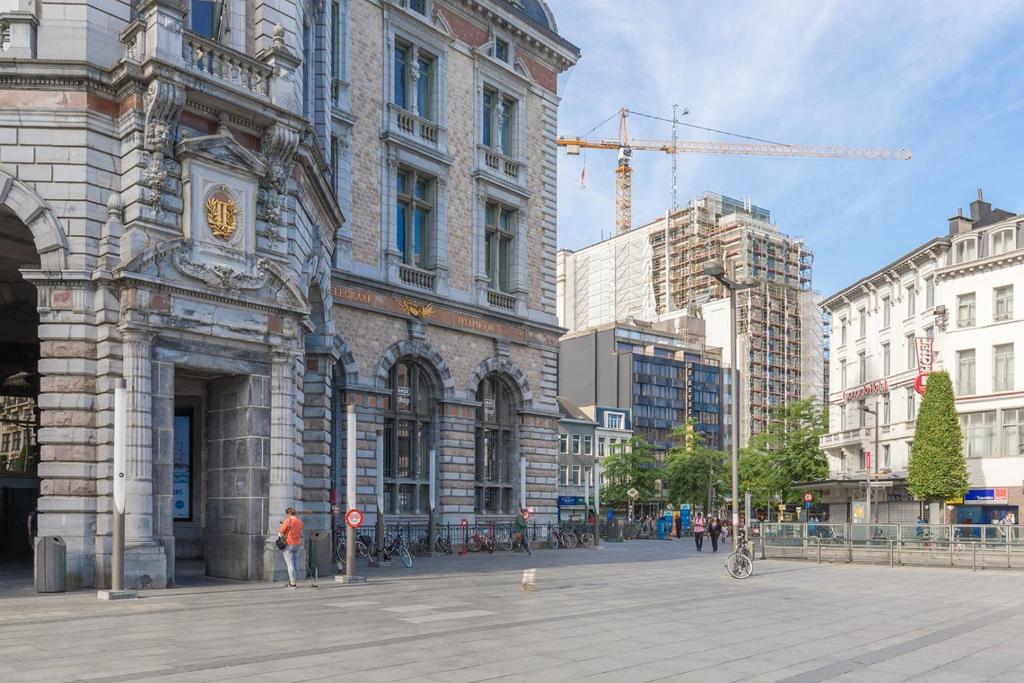 een groot gebouw met een klok erop in een stad bij Leonardo Hotel Antwerpen in Antwerpen