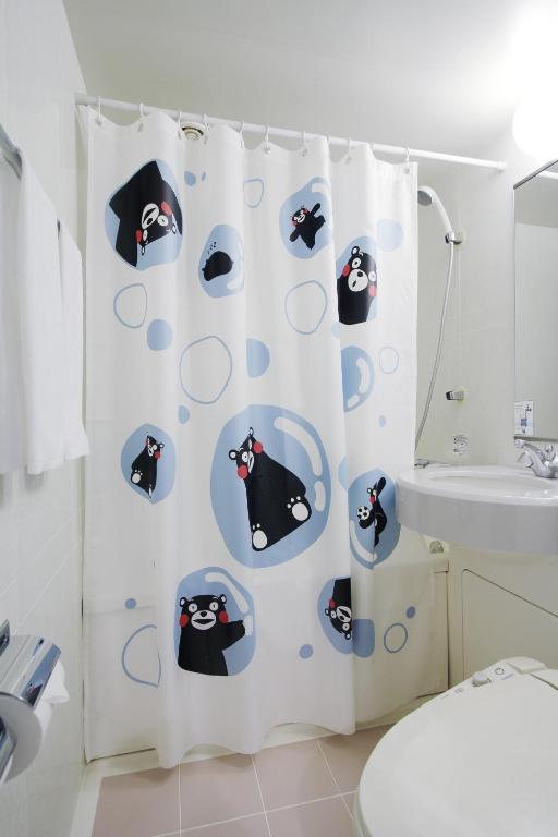 a bathroom with a penguin shower curtain at Mitsui Garden Hotel Kumamoto in Kumamoto