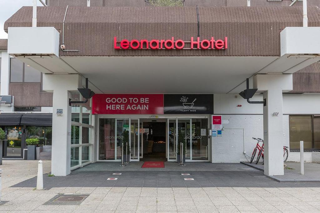 a hotel with a red sign on the front of a building at Leonardo Hotel Lelystad City Center in Lelystad