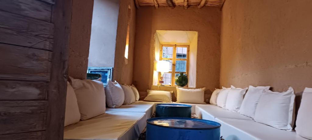 a room filled with white pillows and a window at Kasbah ait Moussa in El Kelaa des Mgouna