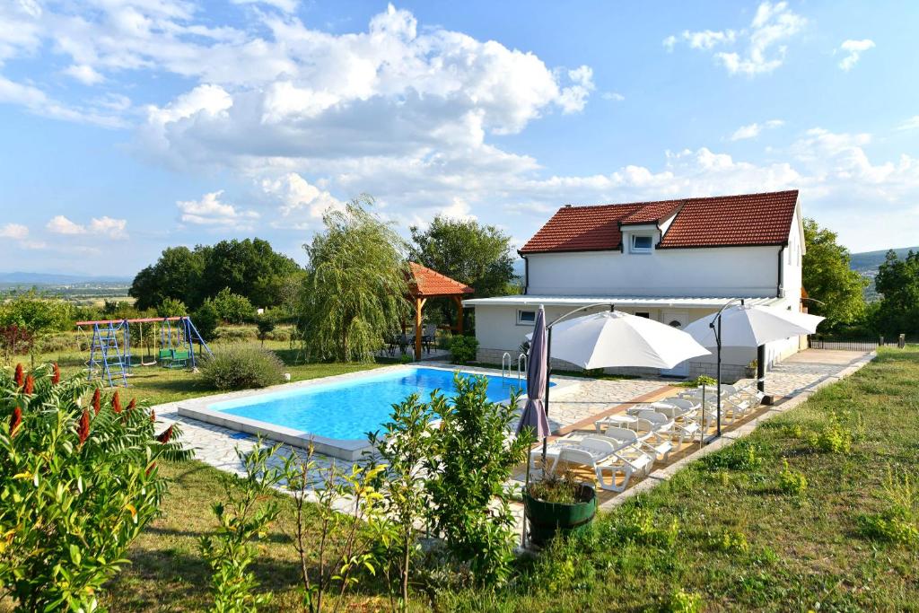 eine Villa mit einem Pool und einem Haus in der Unterkunft Villa Manuela in Hrvace