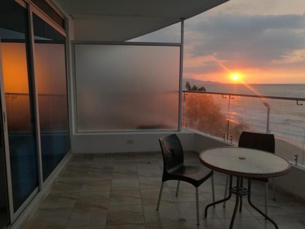 a balcony with a table and chairs and a view of the ocean at Apartment (Grand Diamond Beach) Tonsupa in Tonsupa