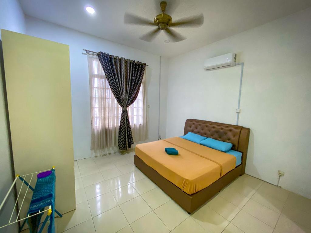 sypialnia z łóżkiem i wentylatorem sufitowym w obiekcie Che Nonna Beach Homestay w mieście Kampong Gebeng