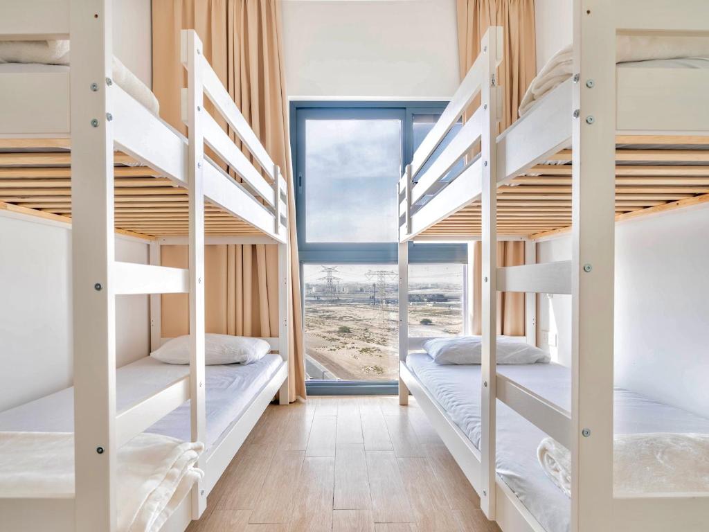 3BDRM Near Metro for Family&Group في دبي: غرفة مع سرير بطابقين مع إطلالة على الشاطئ