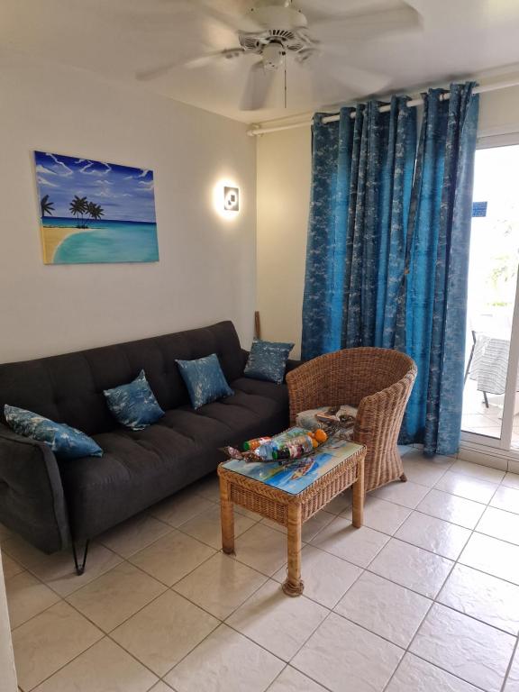 a living room with a couch and a table at appartement spacieux vue sur mer in La Trinité