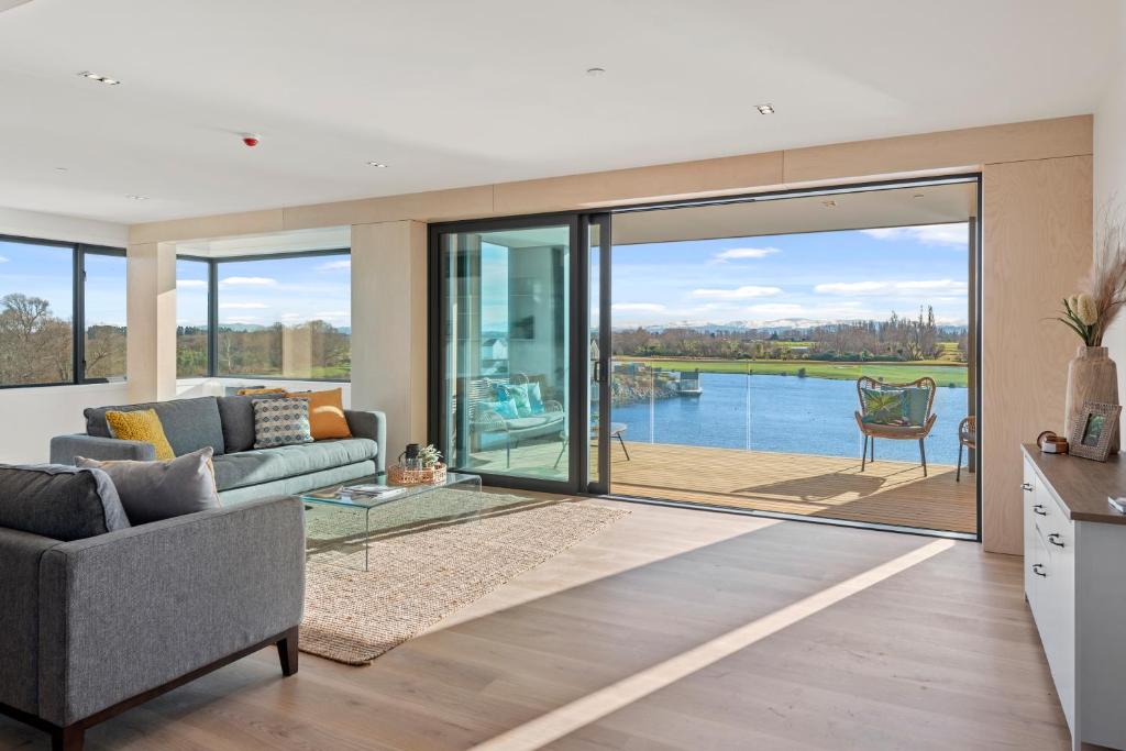 a living room with a couch and sliding glass doors at Clearwater Quays Apartments in Christchurch