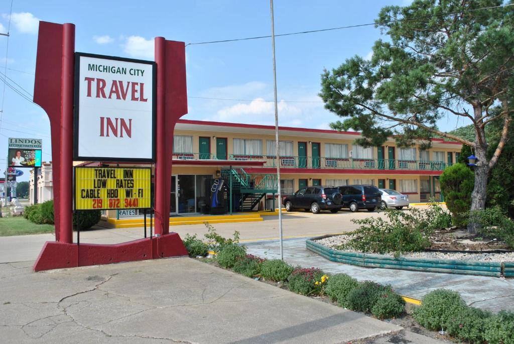 a hotel with a sign in front of a building at Travel Inn Motel Michigan City in Michigan City