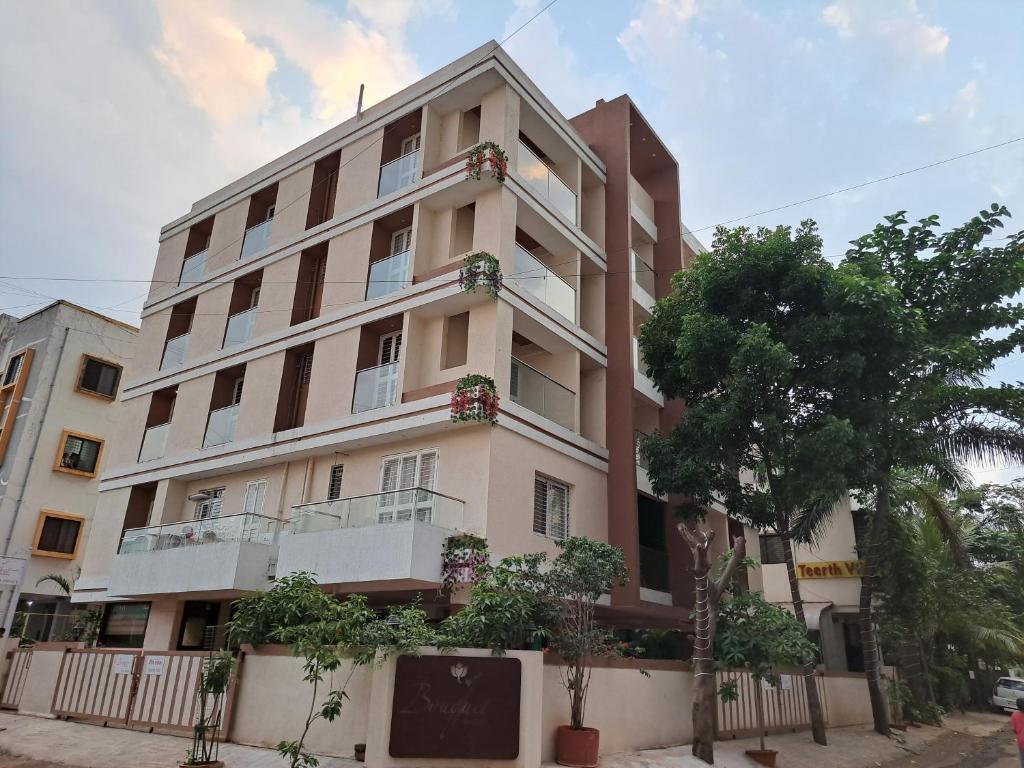 a tall building with plants in front of it at Bouquet Residency in Nashik