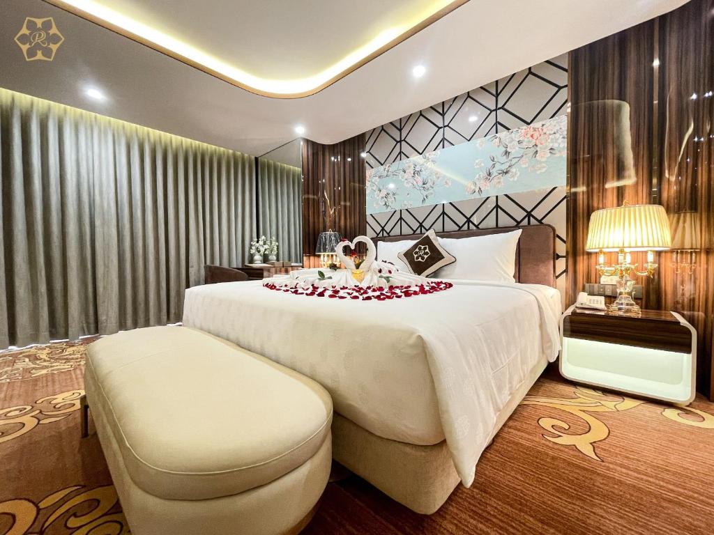 a hotel room with a large bed with roses on it at Cửa Đông Luxury Hotel in Vinh