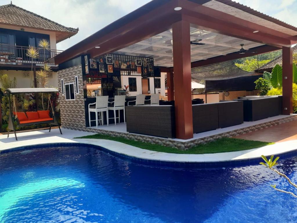 a swimming pool with a patio and an outdoor bar at Villa casamarbella in Karangasem