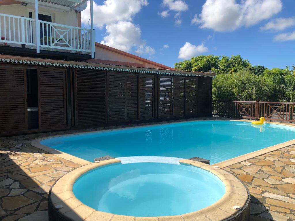 una grande piscina blu con recinzione in legno di La villa exotik a Saint-Louis