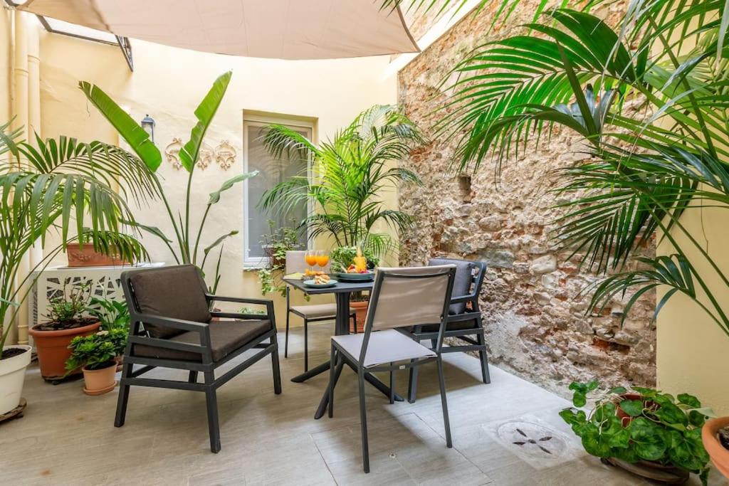 a patio with a table and chairs and plants at Laura Five Senses in Florence