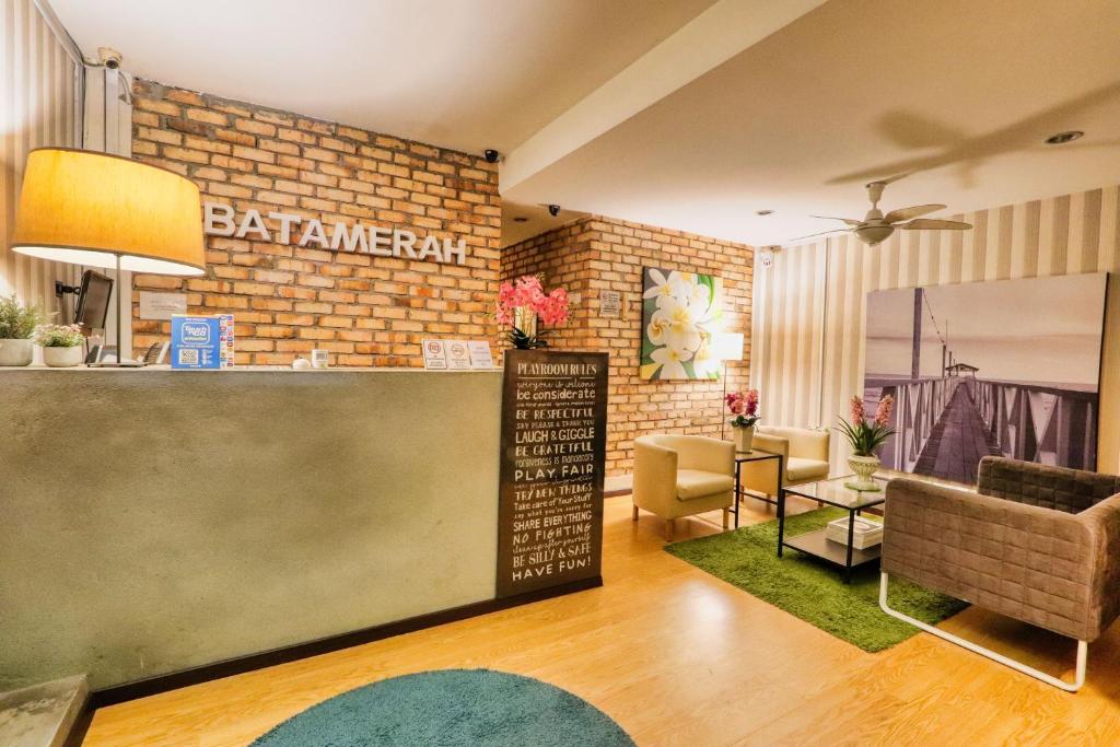 un bar in un soggiorno con muro di mattoni di Bata Merah Boutique Hotel a Banting
