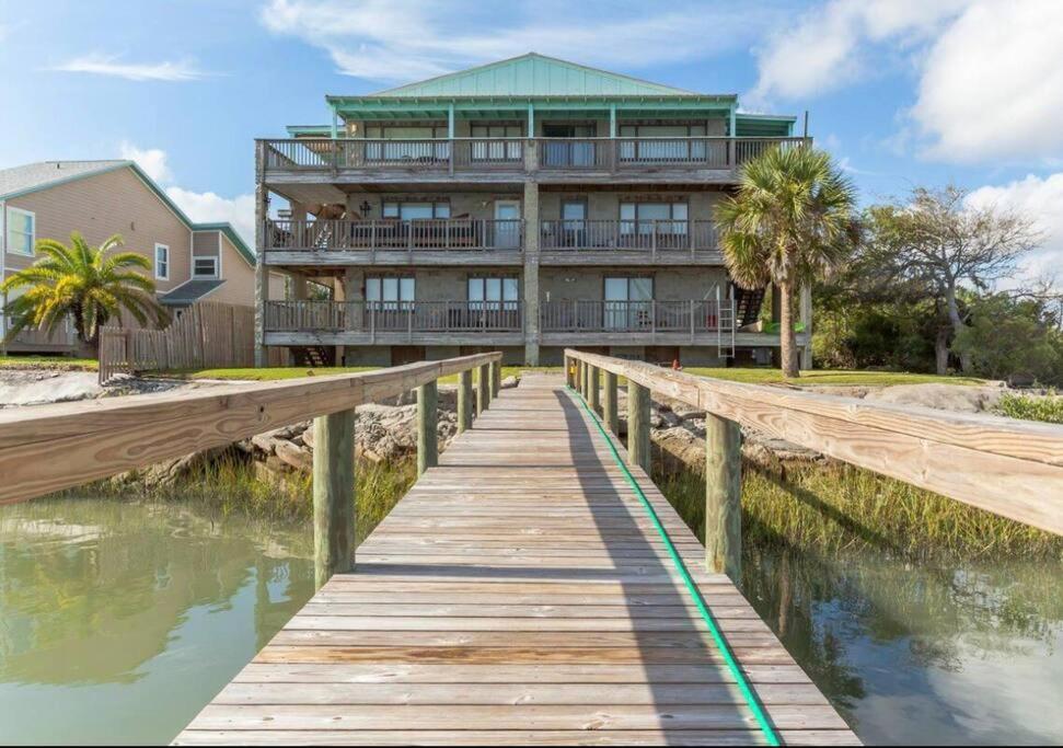 a house on the water with a wooden bridge at Admiral Suite in Saint Augustine