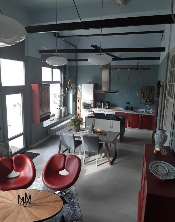 a kitchen with red chairs and a table in it at Ferienwohnung Bad Freienwalde in Bad Freienwalde