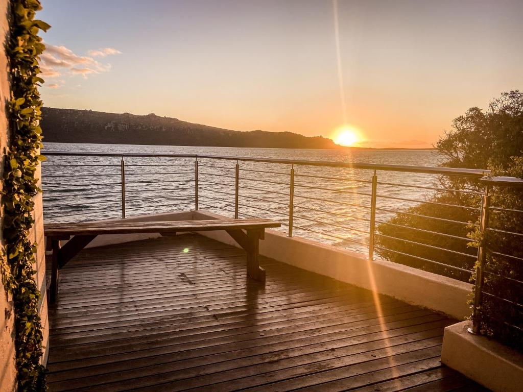 un banc sur le pont d'un navire de croisière au coucher du soleil dans l'établissement Sunset Villa, à Langebaan