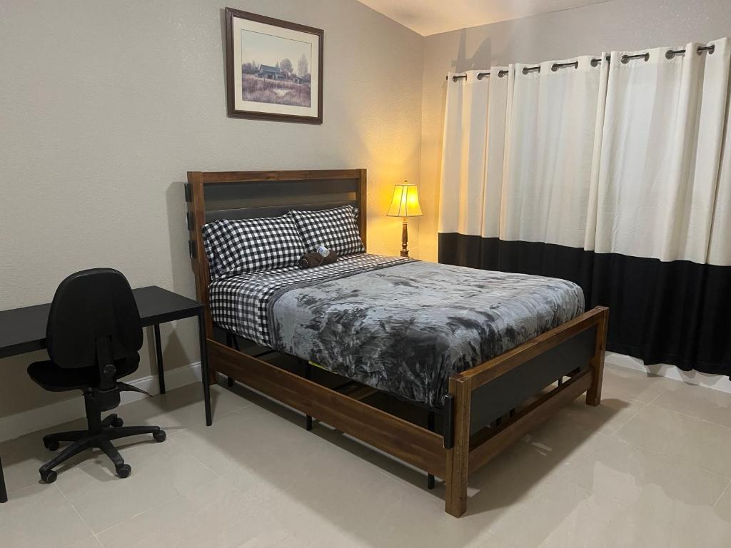 1 dormitorio con cama, escritorio y silla en Oak Ridge House, en Tampa