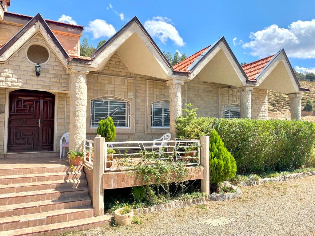 une maison avec un banc en bois devant elle dans l'établissement ATGAL Ferme D'hote, à Azrou