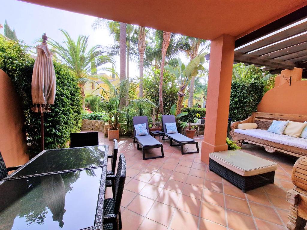 a patio with a table and chairs and a couch at Villa Victoria in Marbella