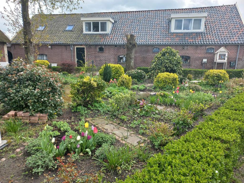 een tuin voor een huis met bloemen bij B&B De Kaagse Boer in Kaag