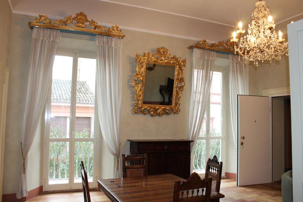 a dining room with a table and a mirror on the wall at Palazzo Trevisani in Porto San Giorgio