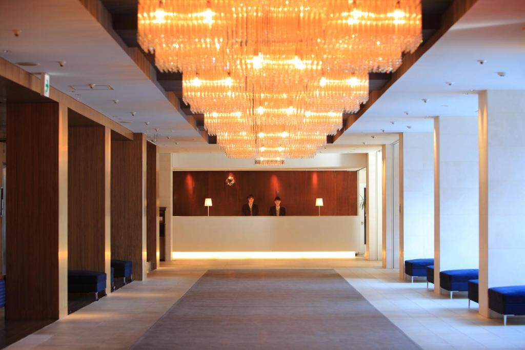 un corridoio di un edificio con un grande lampadario a braccio di Hotel Fuji a Fuefuki
