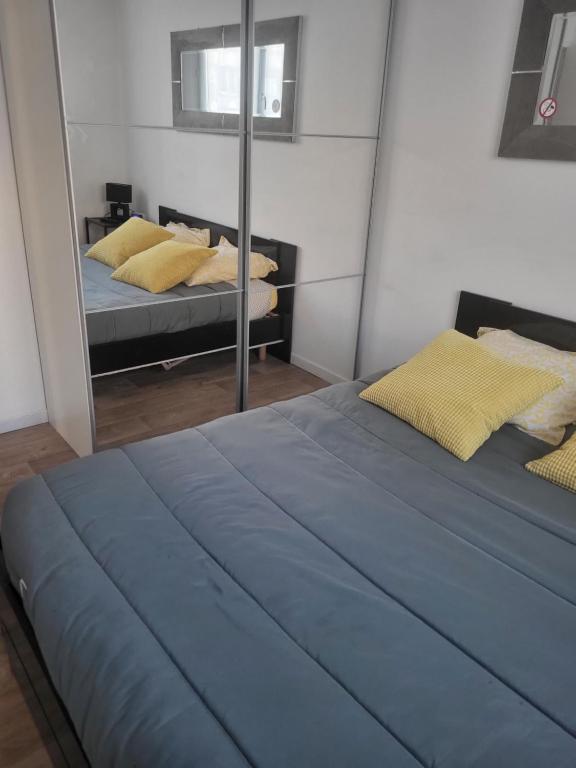 1 Schlafzimmer mit 2 Betten und einem Spiegel in der Unterkunft Dunkerque Malo les bains 15 mn plage in Dunkerque