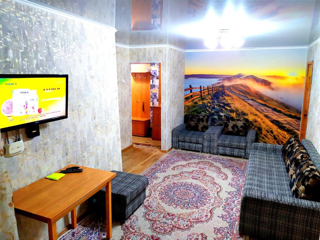 sala de estar con sofá y TV en 3-х комнатная квартира район ЖД вокзала, en Kostanái